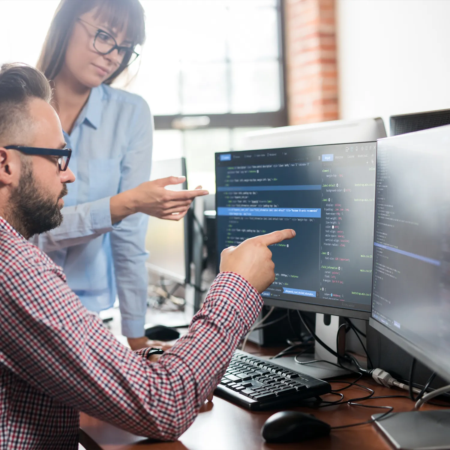 A man and woman looking at a computer screen